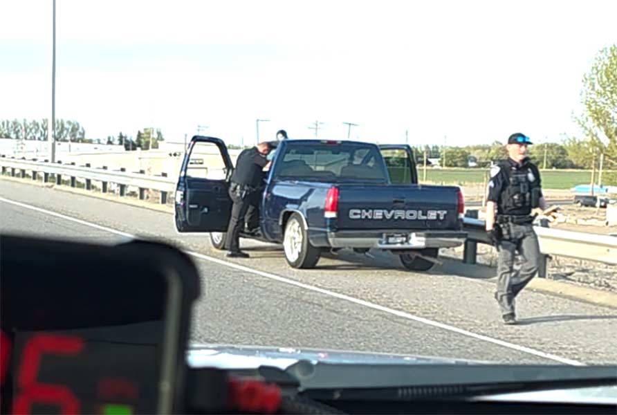 Officers searching a blue Chevrolet pickup following Saturday night arrest. | Courtesy Trent Petersen