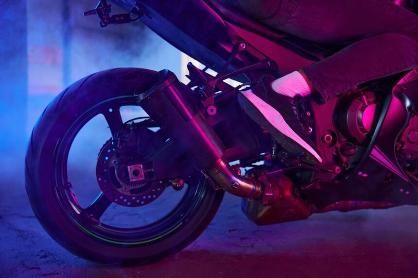 Sport motorcycle wheel view from back in neon light and smoke