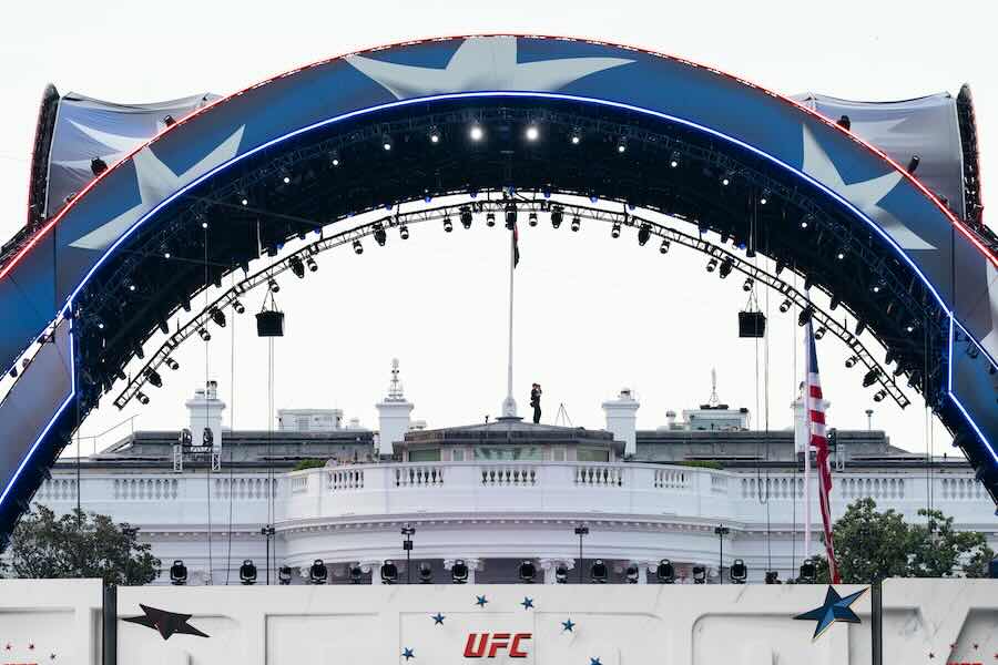 Security at the White House looks through a pair of binoculars during the UFC Fan Fest on the White House Ellipse ahead of Sunday's fight on the South Lawn, Saturday, June 13, 2026, in Washington.