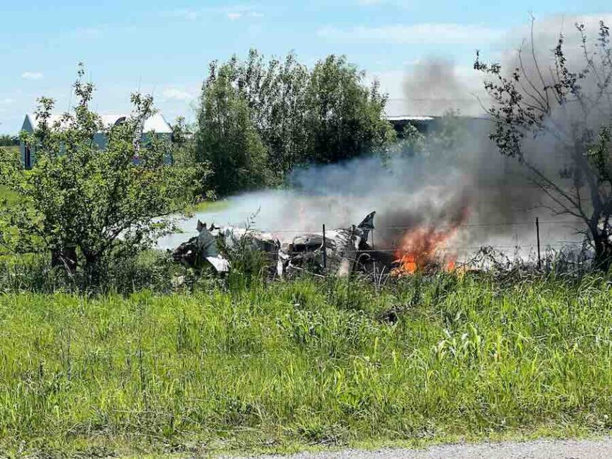 The wreckage of a plane crash burns in a field in Butler, Mo, Sunday, June 14, 2026.