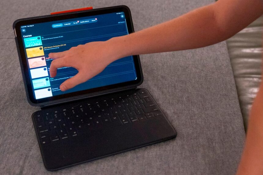 LuAnn Oliver's son demonstrates how he uses an iPad for his classes during a meeting where a group of school parents discussed ways to push back against screen time at the children's school, Saturday, May 9, 2026, in Arlington, Va. | Kevin Wolf, Associated Press