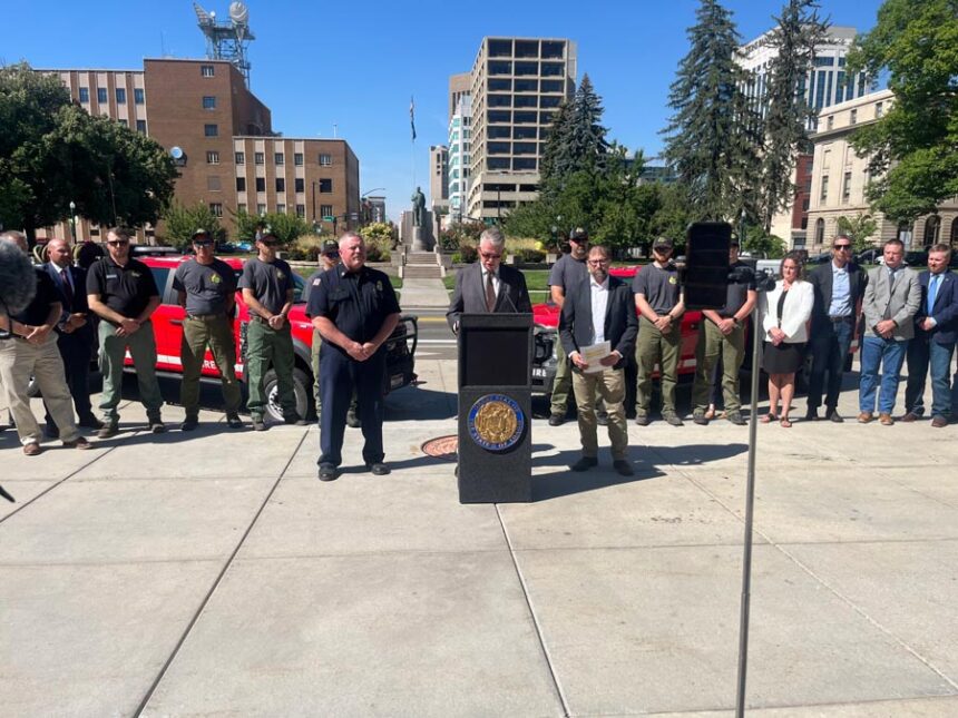 A group of Idaho Department of Lands firefighters join Gov. Brad Little, center, during a fire season press conference June 16, 2026, at the Idaho State Capitol in Boise. | Clark Corbin, Idaho Capital Sun