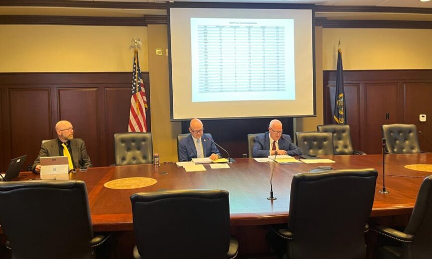 Idaho Secretary of State Phil McGrane, center, and Idaho State Controller Brandon Woolf, right, certify Idaho’s 2026 primary election results on June 9, 2026, at the Idaho State Capitol in Boise. | Clark Corbin, Idaho Capital Sun
