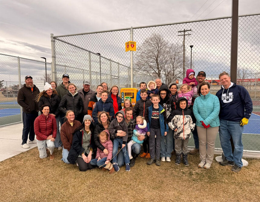 Janelle Palmer's loved ones surround the new automated external defibrillator donated by her family that's located at the Rigby South Park.