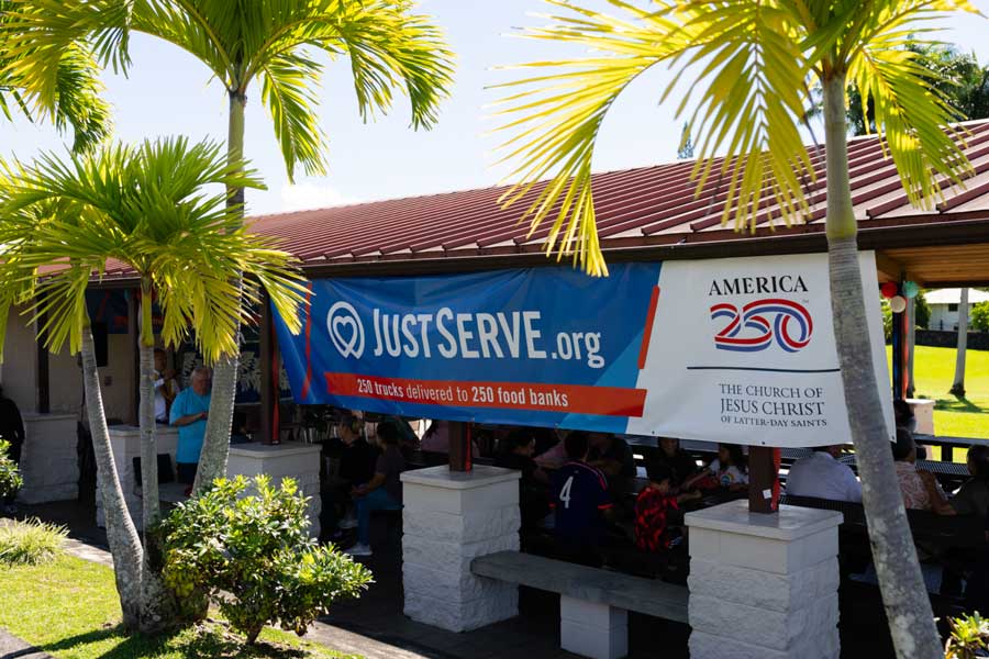 At a Church meetinghouse parking lot in Hilo, Hawaii, on June 13, 2026, nonprofit representatives, members, and friends of The Church of Jesus Christ of Latter-day Saints meet to organize a food donation from the Church as part of the America250 America Gives initiative.