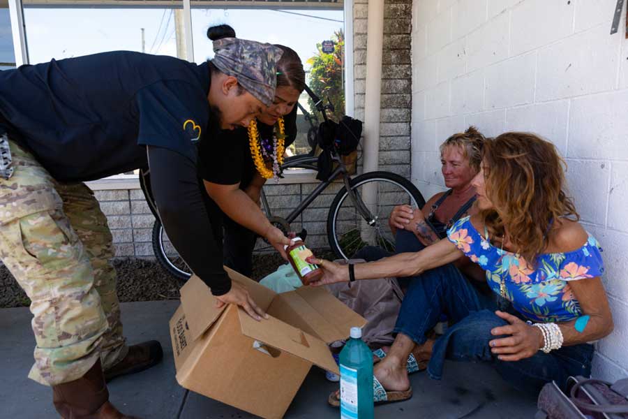 Jodi Durell (left) and Gina Syfert (right) receive food, including donated items from The Church of Jesus Christ of Latter-day Saints, outside The Food Basket in Hilo, Hawaii, on June 13, 2026.