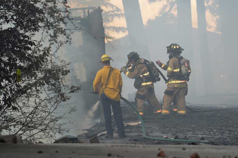 Firefighters from Northern Lakes Fire Protection District work to extinguish a massive house fire at Hayden Lake, in Kootenai County, on Friday, June 19, 2026.