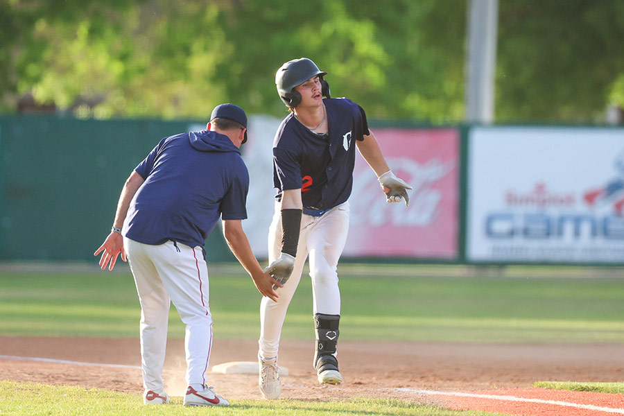 Gate City Grays Trayson Kostial high-fives head coach Rhys Pope while rounding the bases on a home run