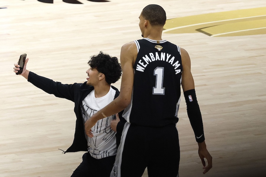 Fan arrested and banned for life after running onto court to take selfie with basketball player