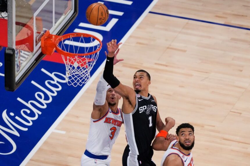 San Antonio Spurs forward Victor Wembanyama (1) shoots as New York Knicks guard Josh Hart (3) and center Karl-Anthony Towns (32) defend during the second half of Game 3 of the NBA Finals basketball series, Monday, June 8, 2026, in New York. (AP Photo/Yuki Iwamura)