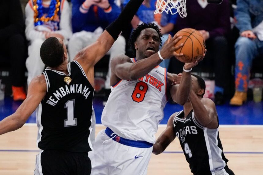 New York Knicks forward Og Anunoby (8) shoots between San Antonio Spurs forward Victor Wembanyama (1) and guard De'aaron Fox (4) during the first half of Game 4 of the NBA Finals basketball series, Wednesday, June 10, 2026, in New York. (AP Photo/Ross D. Franklin)