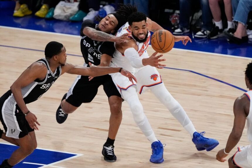 New York Knicks center Karl-Anthony Towns, right, and San Antonio Spurs guard Stephon Castle (5) battle for the ball during the second half of Game 4 of the NBA Finals basketball series, Wednesday, June 10, 2026, in New York. (AP Photo/Ross D. Franklin)