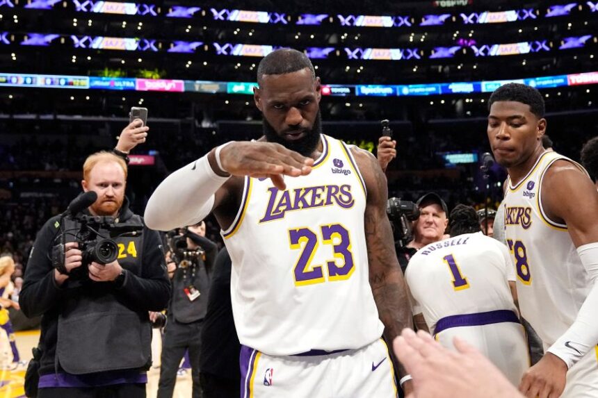 FILE - Los Angeles Lakers forward LeBron James salutes public address announcer Lawrence Tanter prior to an NBA basketball game against the Denver Nuggets Saturday, March 2, 2024, in Los Angeles. (AP Photo/Mark J. Terrill,File)