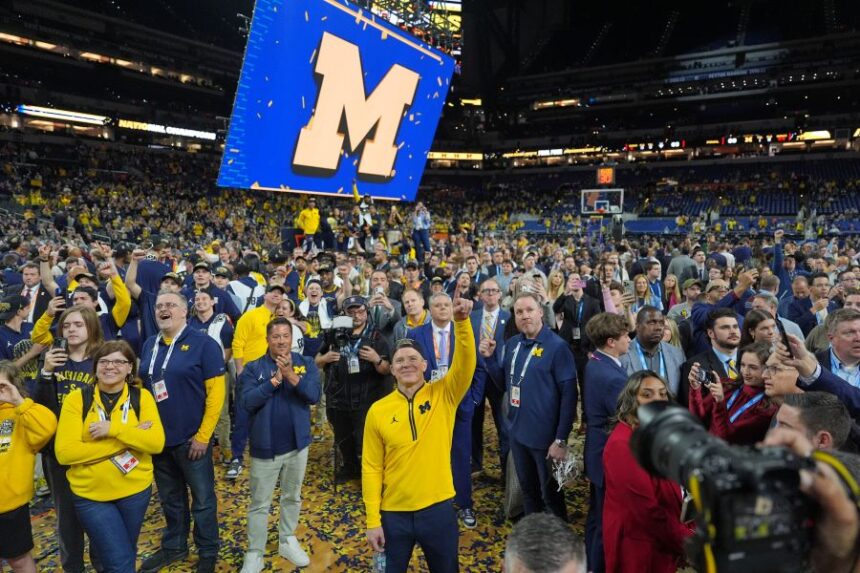 FILE - Michigan head coach Dusty May celebrates after defeating UConn in the NCAA college basketball tournament national championship game at the Final Four, April 7, 2026, in Indianapolis. (AP Photo/Michael Conroy, File)