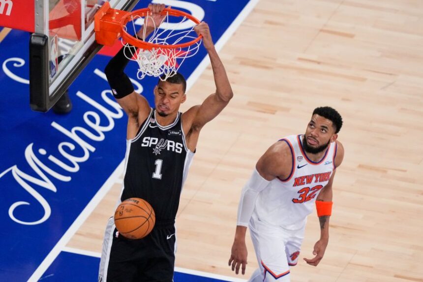 San Antonio Spurs forward Victor Wembanyama (1) dunks as New York Knicks center Karl-Anthony Towns (32) looks on during the second half of Game 3 of the NBA Finals basketball series, Monday, June 8, 2026, in New York. (AP Photo/Yuki Iwamura)