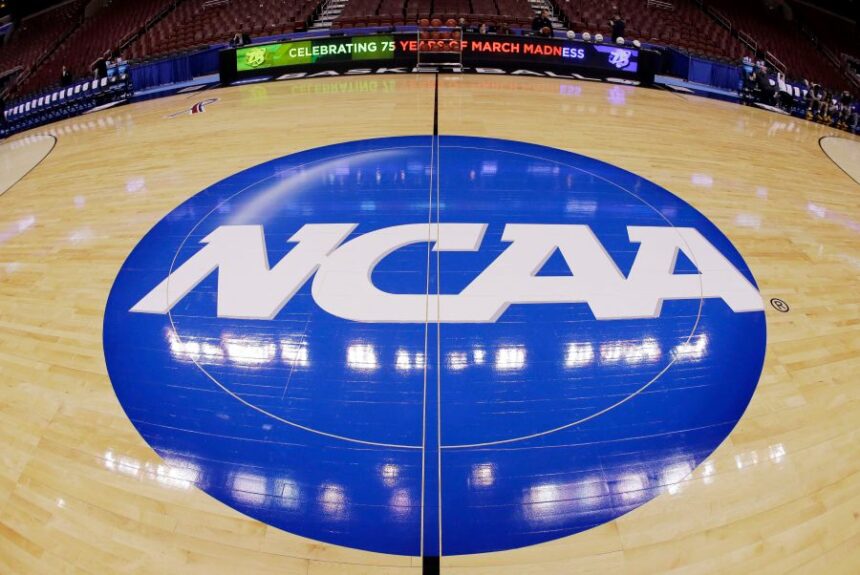 FILE - This photo taken with a fisheye lens shows the NCAA logo displayed at mid-court before Albany's practice for a second-round game of the NCAA college basketball tournament March 21, 2013, in Philadelphia. (AP Photo/Matt Slocum, File)