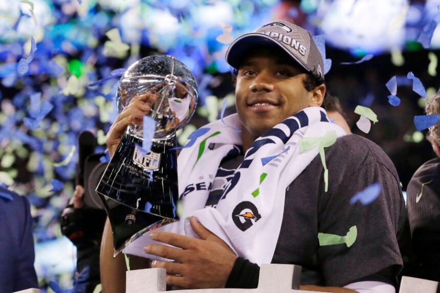 FILE - Seattle Seahawks' quarterback Russell Wilson holds the Lombardi Trophy after the NFL Super Bowl XLVIII football game, Feb. 2, 2014, in East Rutherford, N.J. (AP Photo/Julio Cortez, File)