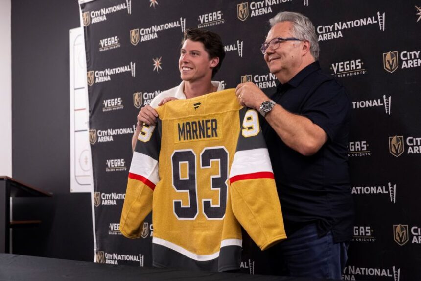 FILE - Newly-acquired Golden Knights forward Mitch Marner, left, poses for a photo with his jersey alongside general manager Kelly McCrimmon, July 1, 2025, in Las Vegas. (Chase Stevens/Las Vegas Review-Journal via AP, File)