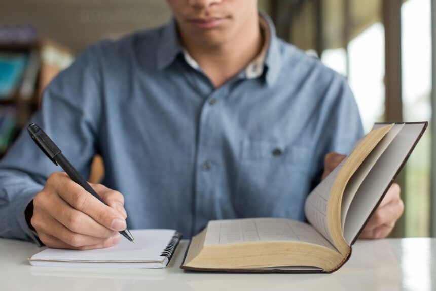 student reads book and takes notes indoors 2026 01 11 09 25 04 utc