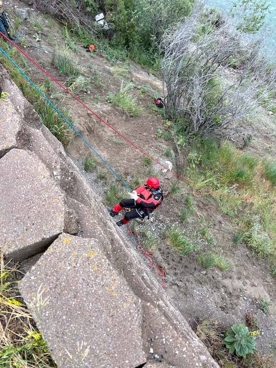 rescues rappelling down retaining wall