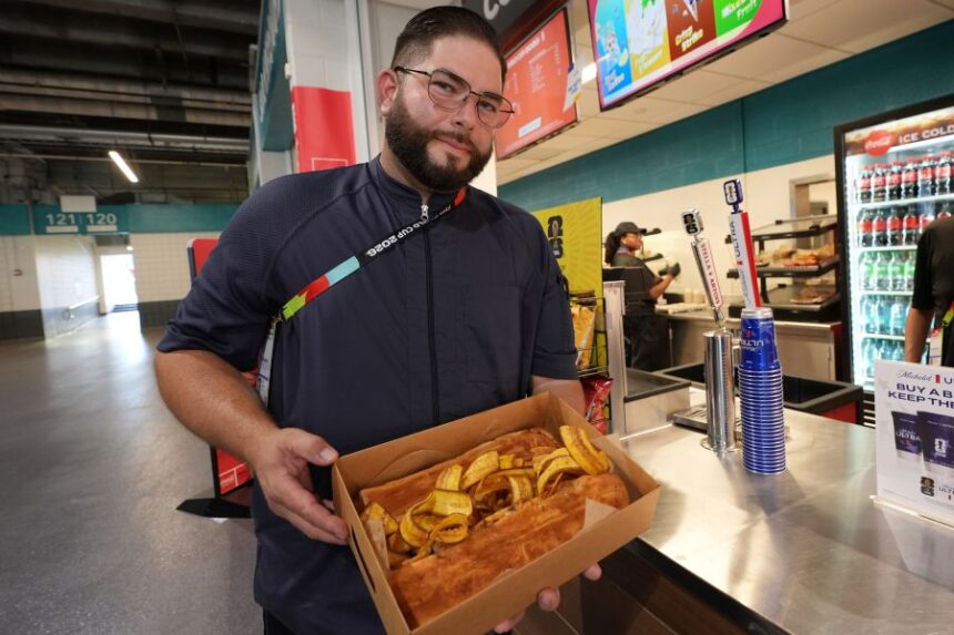 Lazaro Luya, the concession chef at Sol Cubano, displays their special, pan with lechon and fresh mariquitas at Miami Stadium Sunday, June 21, 2026, in Miami Gardens, Fla. (AP Photo/Marta Lavandier)