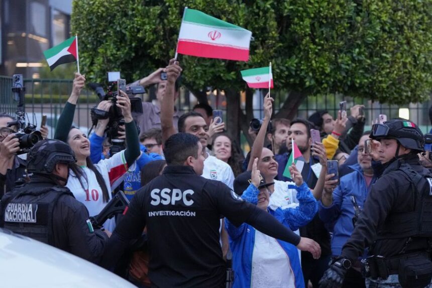 Fans for team Iran wave as players arrive for the World Cup soccer tournament in Tijuana, Mexico, Sunday, June 7, 2026. (AP Photo/Gregory Bull)
