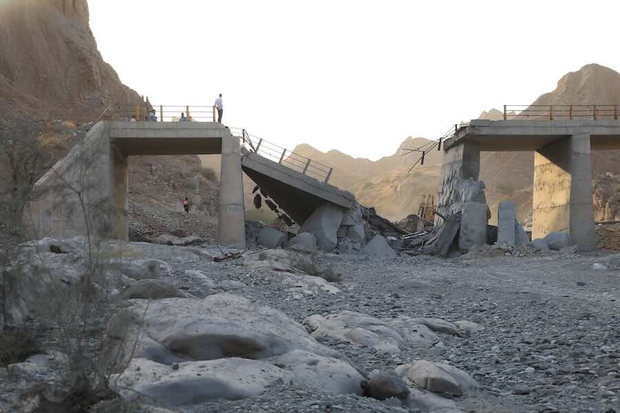 People stand on a bridge destroyed after a strike in Hormozgan province, southern Iran, Saturday, July 18, 2026.