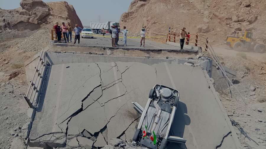 An overturned car sits on a section of a destroyed bridge after a strike in Hormozgan province, southern Iran, Saturday, July 18, 2026.