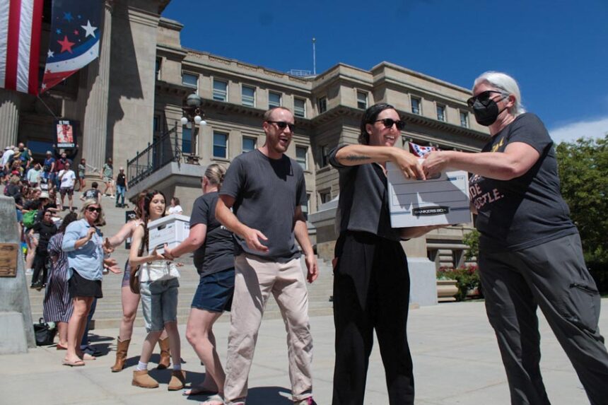 Volunteers pass boxes of signatures supporting a ballot initiative to end Idaho’s strict ban on abortion on July 2, 2026, outside the state Capitol in Boise. | Abigail Gerstein, Idaho Capital Sun