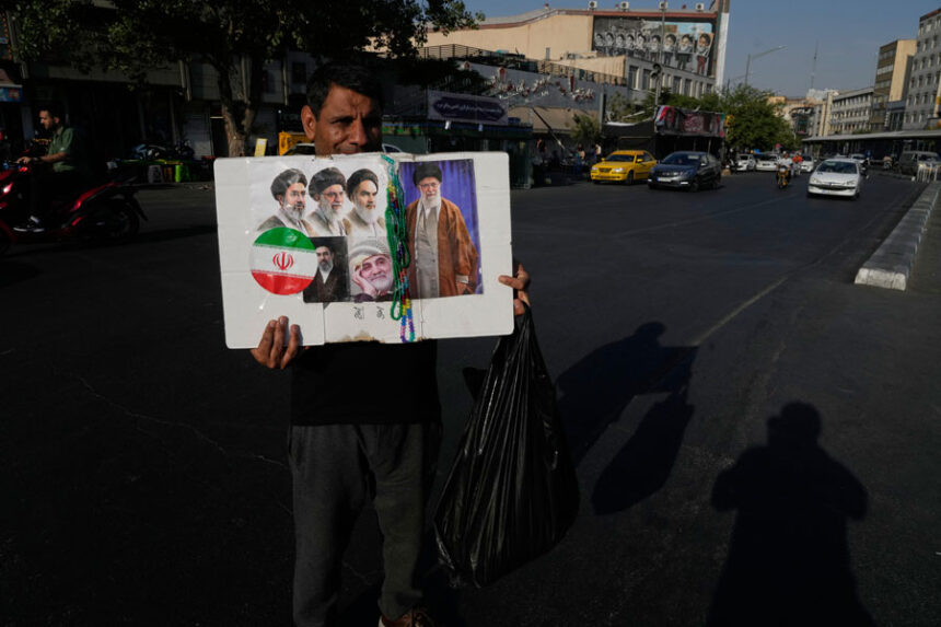 A man displays a placard with portraits of the current and late supreme leaders and the late Revolutionary Guard Gen. Qassem Soleimani at the Islamic Revolution Square in downtown Tehran, Iran, Saturday, July 18, 2026. | Vahid Salemi, Associated Press