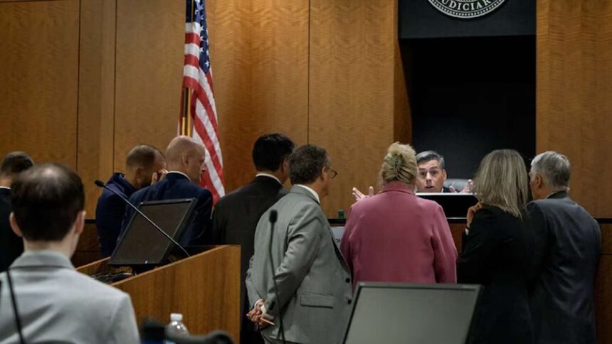 Tyler Robinson, left, who is accused in the fatal shooting of Charlie Kirk, sits while Judge Tony Graf confers with attorneys during his preliminary hearing at the 4th District Courthouse in Provo, Utah.