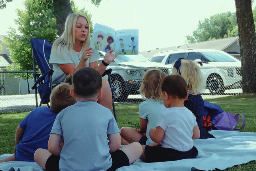 Carrie Terry, a Menan mom reading to kids at Menan City Park during the library's Summer Reading in the Park program. | Photo taken from documentary
