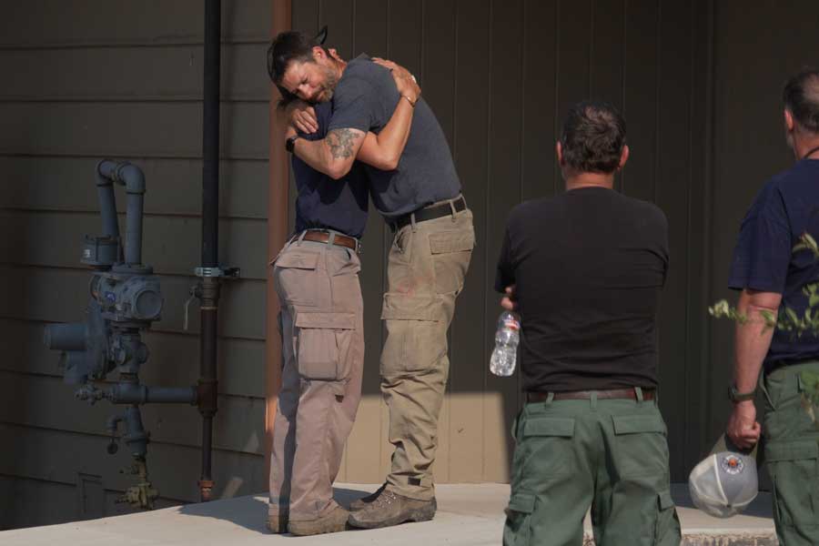 First responders embrace during a procession Monday, June 29, 2026, in Grand Junction, Colorado, for the three firefighters who died while battling the Snyder Fire along the Utah-Colorado border.