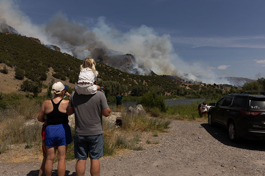 Over dozens of community members made their way near Hesie Hot Springs to watch the Big Rock fire. A family with their daughter watch crews battle the blaze. | Daniel V. Ramirez, EastIdahoNews.com
