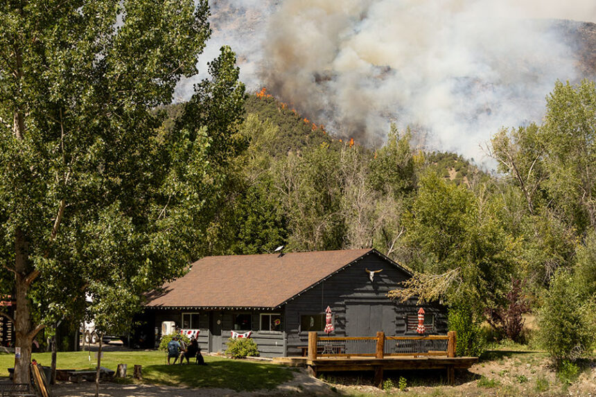 Two campers at the Mountain River Ranch talking with one another as the Big Rock fire blazes in the background. | Daniel V. Ramirez, EastIdahoNews.com