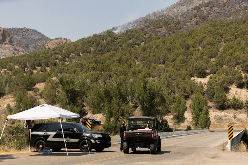 A deputy with the Jefferson County Sheriff's Office talking with a community member at the Heise Bridge. East Heise Road has been closed to the public since Friday, as fire crews battle the Big Rock Fire. | Daniel V. Ramirez, EastIdahoNews.com