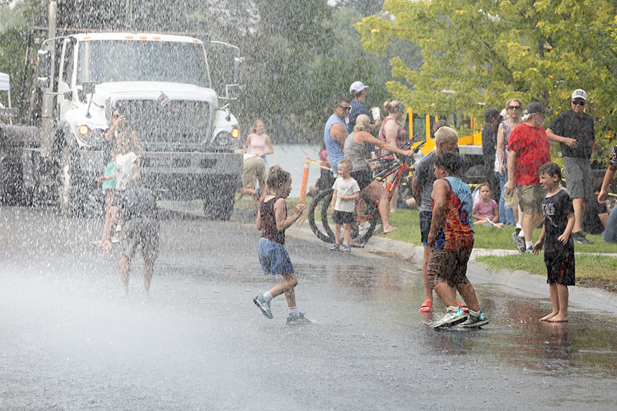 With temperatures reaching into the 90s, members of the Idaho Falls Fire Department sprayed community members to help them cool down. | Daniel V. Ramirez, EastIdahoNews.com