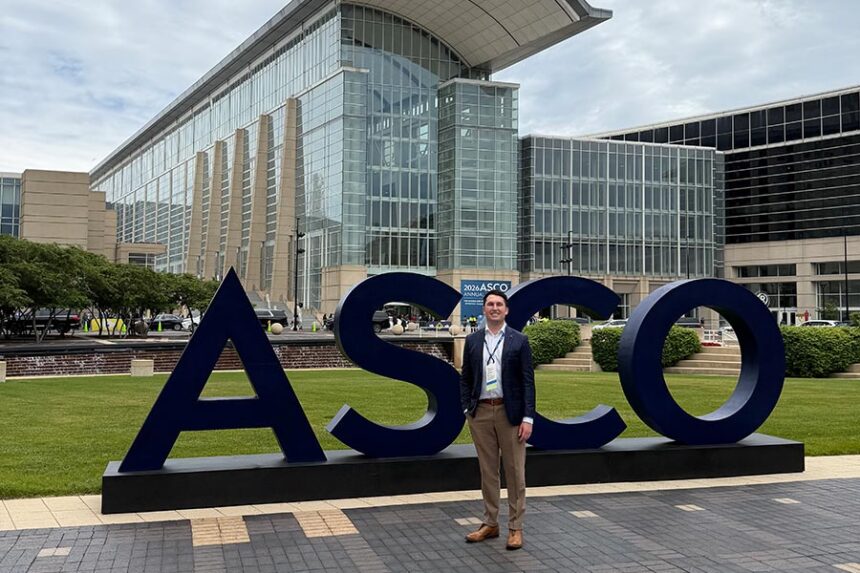 Daniel Thomas Jones, DO, MBA, MHS, in front of the ASCO sign at the 2026 American Society of Clinical Oncology Annual Meeting in Chicago, where he presented oncology research. | Couretsy of Dr. Daniel Jones
