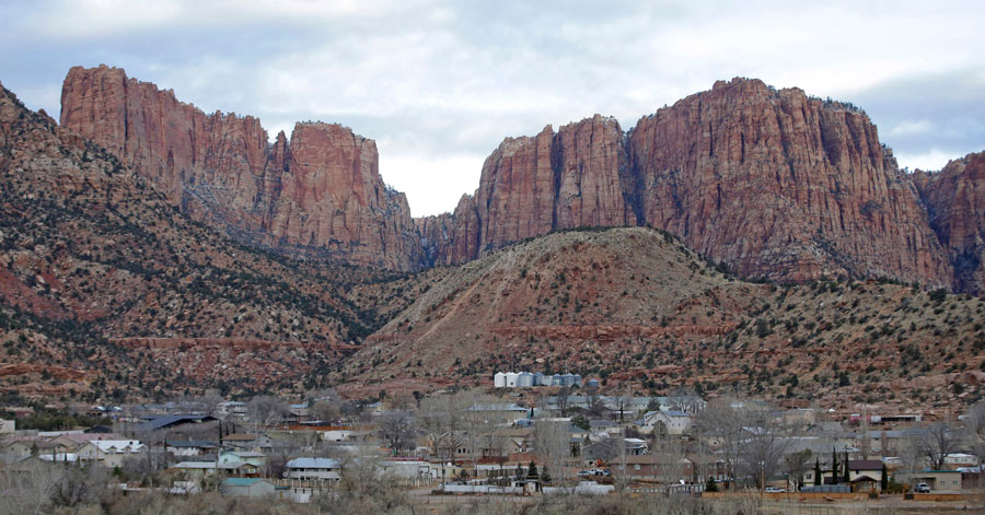 This photo shows Hildale, Utah, sitting at the base of Red Rock Cliff mountains, with its sister city, Colorado City, Ariz., in the foreground, Dec. 16, 2014. (AP Photo/Rick Bowmer, File)