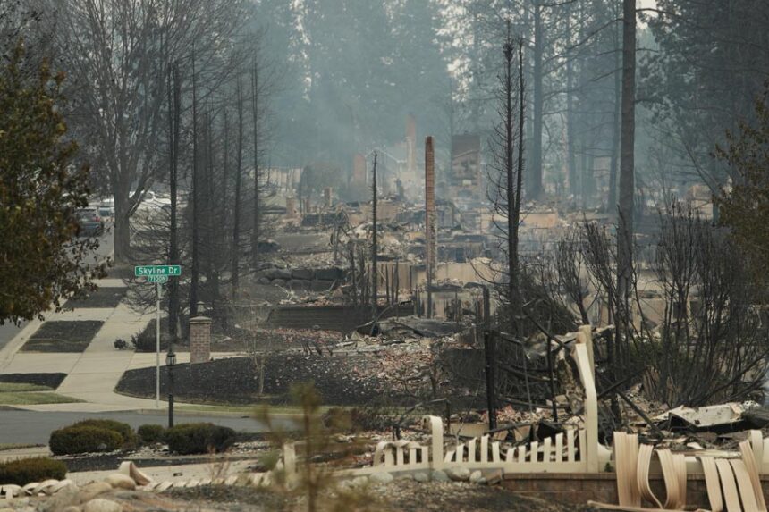 Structures along W. Tiffany Ave. are burned to the ground after a wildfire, Sunday, Aug. 2, 2026, in Spokane, Wash. (AP Photo/Young Kwak)