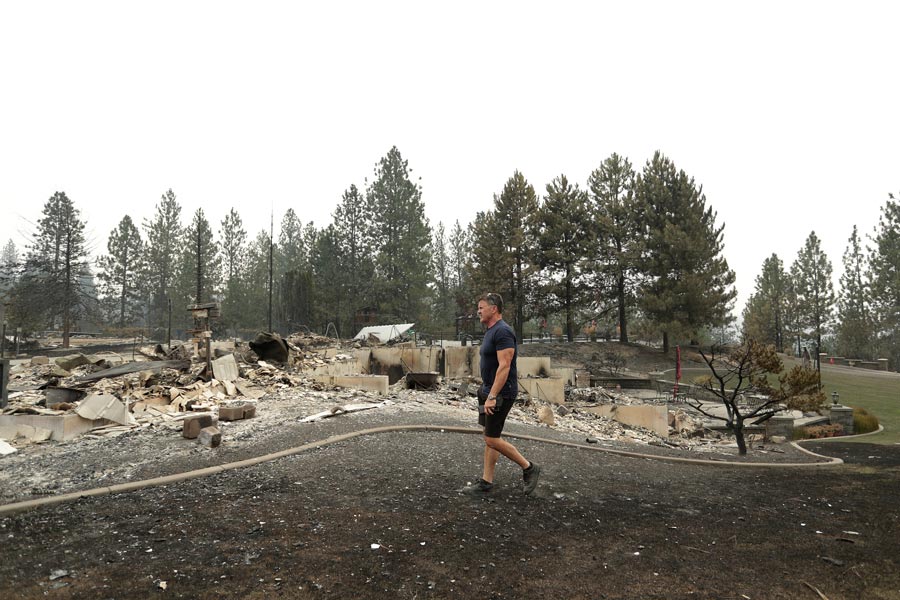 Dan Munson walks in the backyard of his home on W. TIffany Ave. after it burned in a wildfire, Sunday, Aug. 2, 2026, in Spokane, Wash. | Young Kwak, Associated Press