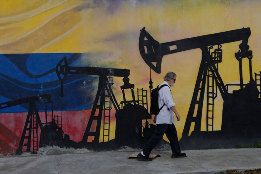 A pedestrian walks past a mural featuring oil wells in Caracas, Venezuela, Saturday, Aug 29, 2026, a day after President Donald Trump announced a deal giving the United States a stake in Venezuela’s oil reserves. (AP Photo/Pedro Mattey)