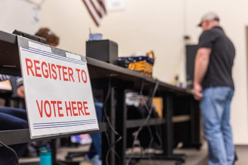 Poll workers help voters register to vote for the primary election on May 21, 2024, at Thunder Ridge High School in Idaho Falls. (Photo by Pat Sutphin for the Idaho Capital Sun)
