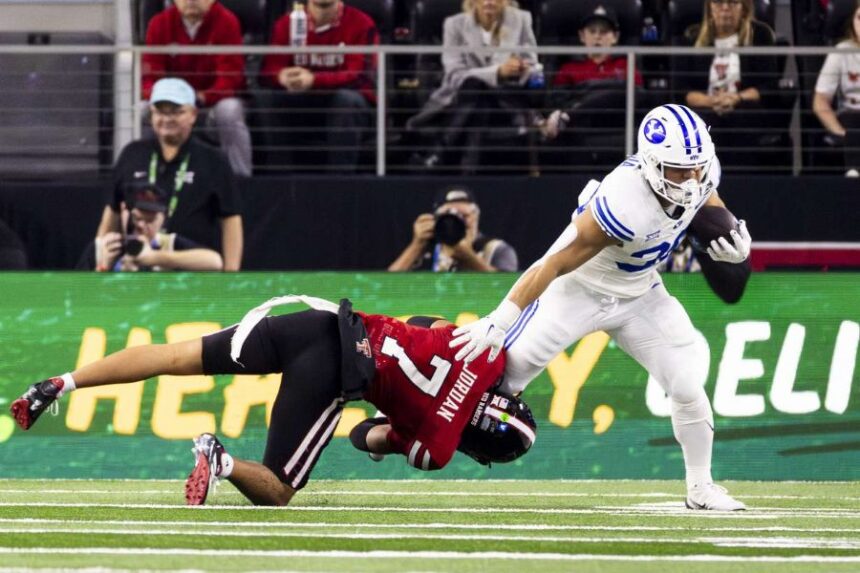 BYU running back Sione Moa (30) is downed by Texas Tech Red Raiders defensive back Brenden Jordan (7) during the Big 12 championship game held at AT&T Stadium in Arlington, Texas, on Saturday, Dec. 6, 2025. (Photo: Isaac Hale, Deseret News)
