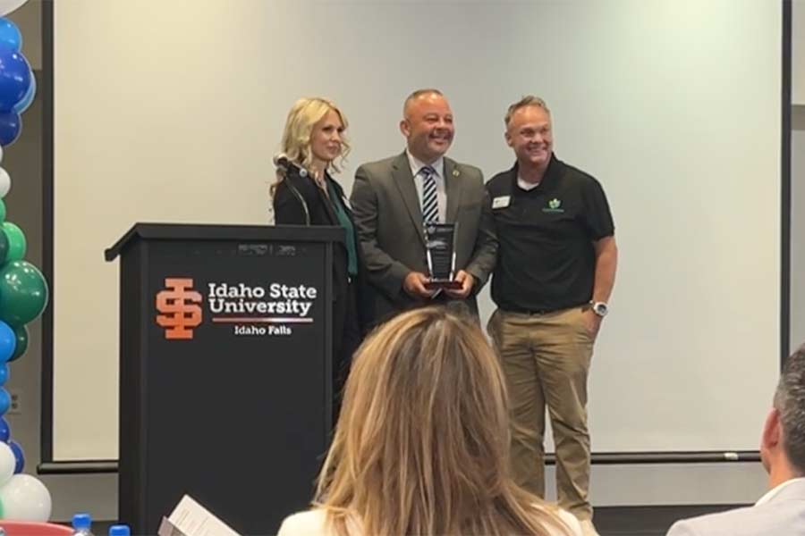 Stephanie Taylor-Thompson, left, and James Manwaring, right, present Monty Burks with an award during Recover Out Loud on Saturday. | Rett Nelson, EastIdahoNews.com