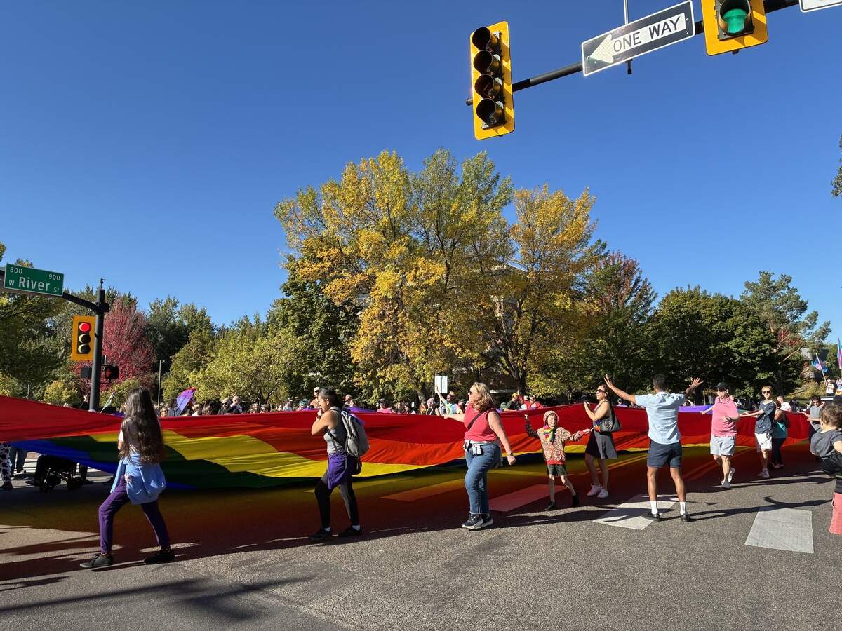 Boise Pride marchers carry a large Pride flag. Sally Krutzig