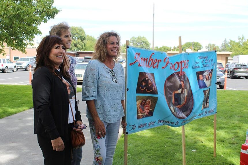 Amber Hoopes' family members stand next to the sign to raise awareness for her disappearance. | Kaitlyn Hart, EastIdahoNews.com.