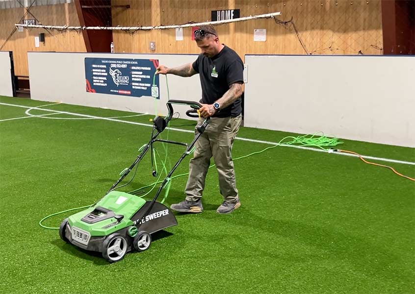 Ty Owen with Idaho Turf Co. sweeping the turf on Tuesday in preparation for the ribbon-cutting. | Rett Nelson, EastIdahoNews.com