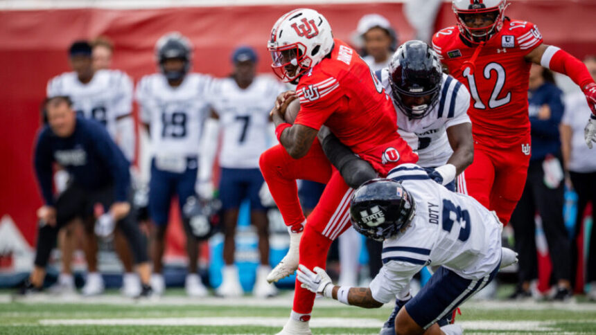 Utah Utes quarterback Devon Dampier (4) is tackled by Utah State Aggies safety Charger Doty (3) during a football game at Rice-Eccles Stadium in Salt Lake City on Saturday, Sept. 19, 2026.
