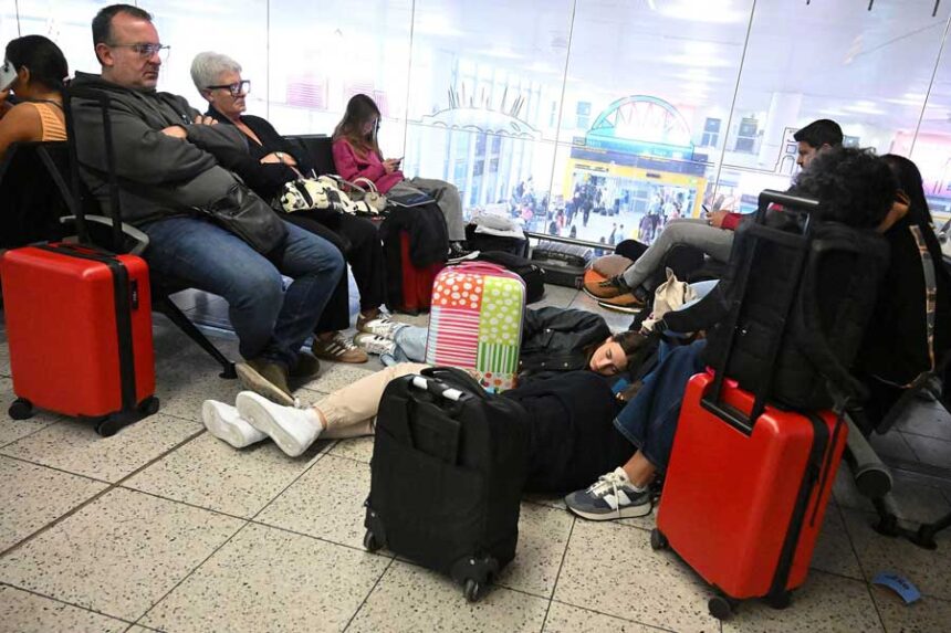 People lay on the floor with their luggage at London's Gatwick Airport on Wednesday, Sept. 9, 2026. A number of key regional carriers were forced to cancel hundreds of flights following the system failure.